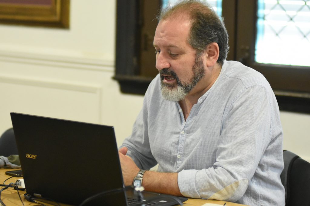 El concejal Carlos Cardozo preside la reunión semipresencial a través de su computadora, desde el anexo Alfredo Palacios